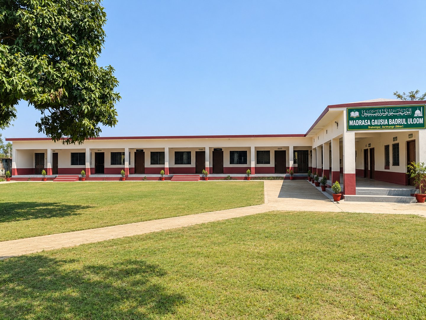 The main building and courtyard of Madarsa Gausia Badrul Uloom, with the madarsa name board above the entrance